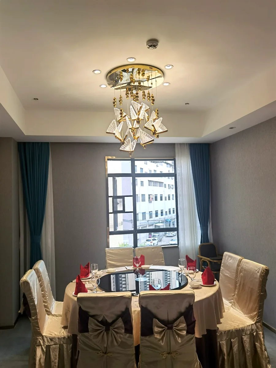 Private dining room &mdash; gold butterfly crystal chandelier over a round banquet table