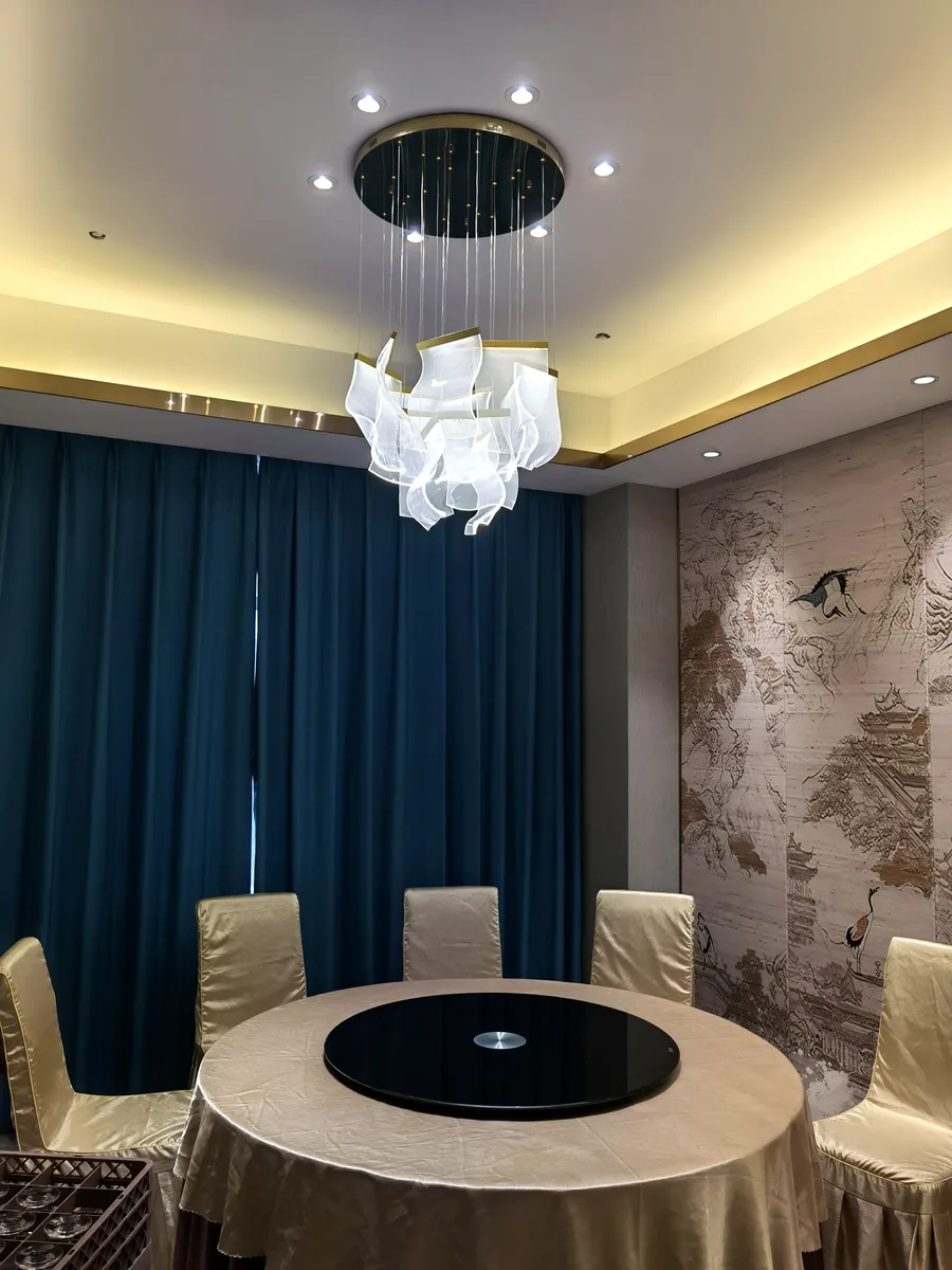 Private dining room &mdash; sculptural white silk wave chandelier over a round table