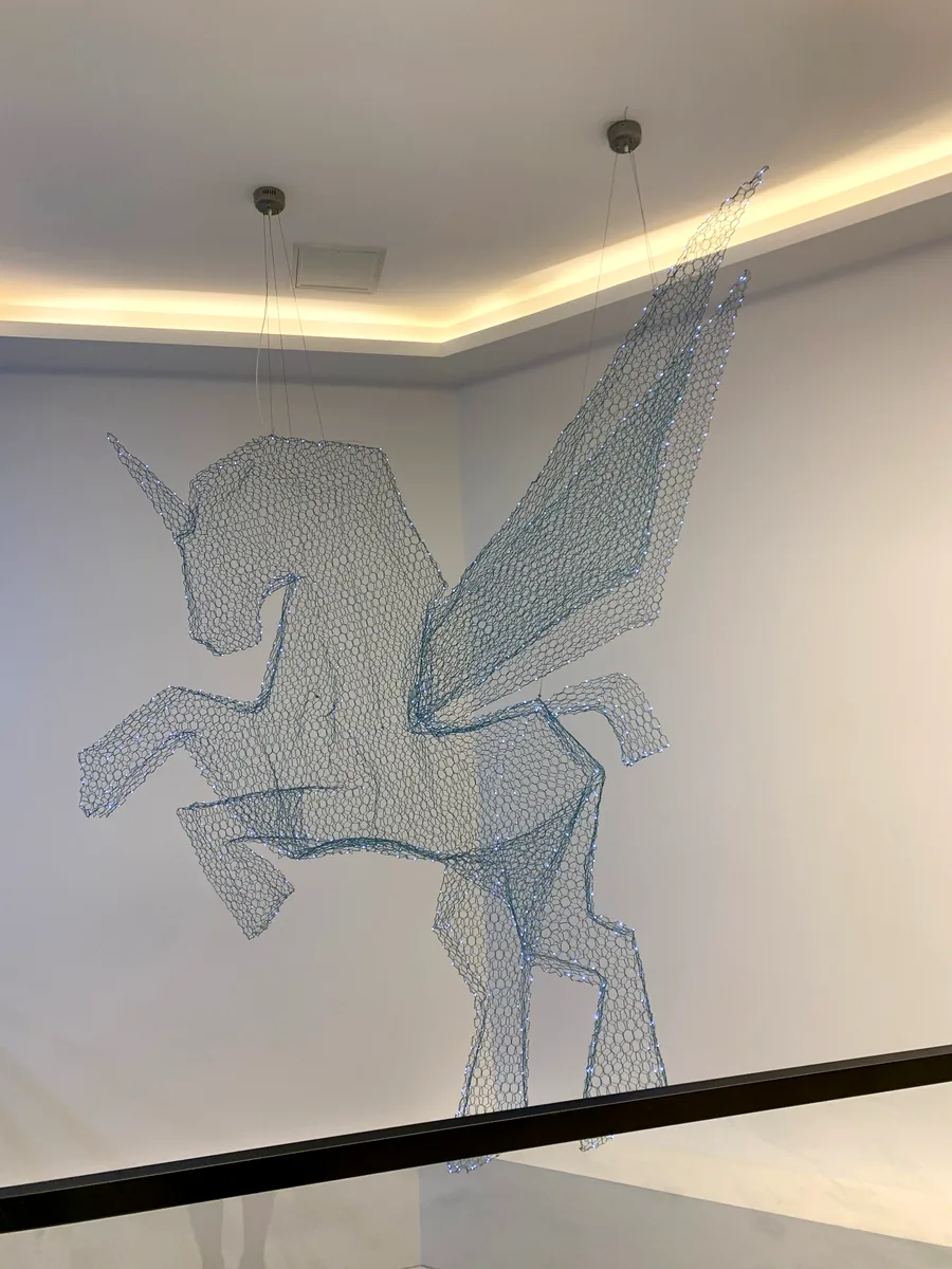 Unicorn light sculpture hand-woven from mesh with stitched LED points
