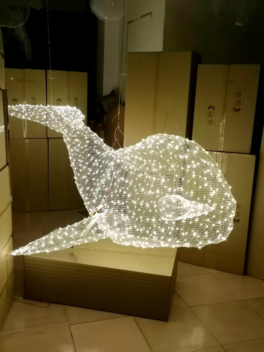 Suspended whale light sculpture hand-woven from mesh and LED, on lit test